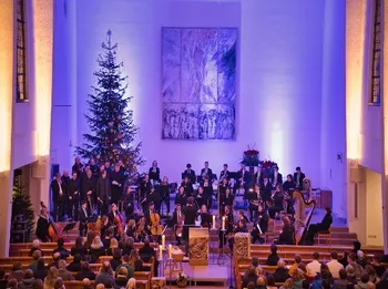 Orchester vor dem Weihnachtsbaum, blaues Licht